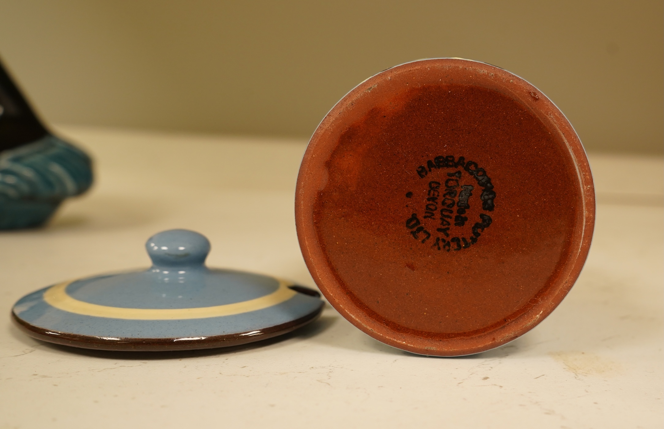A Poole Pottery hors d’ouevres dish, a dolphin, a box and cover and a Torquay ware Brixham jar